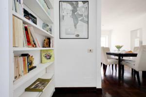 een eetkamer met een witte muur en boekenplanken bij Vatican Charme in Rome