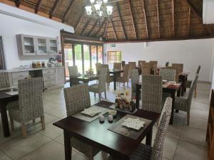 a dining room with tables and chairs and a kitchen at Be My Guest Too in Upington