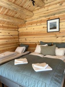 um quarto com uma cama num chalé de madeira em Fjelleventyret gårdsovernatting em Skjåk