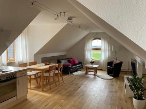 a kitchen and living room with a table and chairs at Sonniges Jura Loft im Golf Paradies Hilzhofen in Pilsach