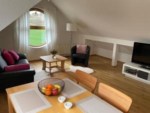 a living room with a bowl of fruit on a table at Sonniges Jura Loft im Golf Paradies Hilzhofen in Pilsach