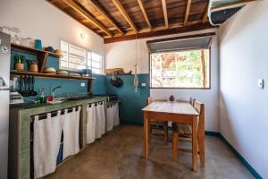 a kitchen with a wooden table and a window at TwoTen° Surf Home in Popoyo