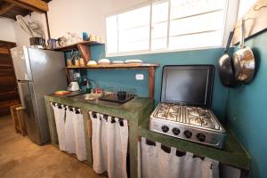 a kitchen with a stove and a sink at TwoTen° Surf Home in Popoyo