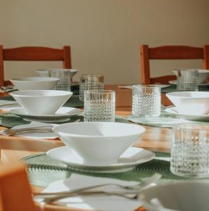 uma mesa de madeira com tigelas e pratos brancos em MountHoff Retreat em Moroeni