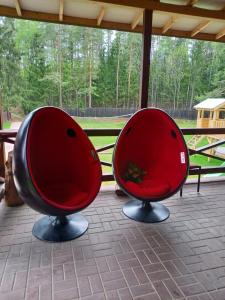 two red chairs sitting on a porch at Lesnoj holiday in Vilnius