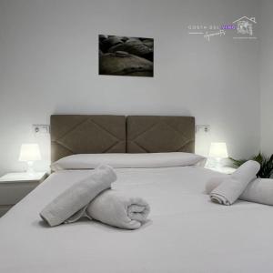 Una cama blanca con dos toallas de peluche. en Apartamento El Mozo, en Labastida
