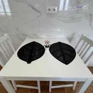 dos sombrillas negras sentadas en una mesa blanca en Apartamento El Mozo, en Labastida