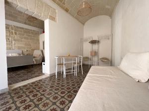 Habitación con cama y mesa con sillas. en NINNI SUITE, en Favignana