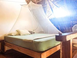 a bed with a net around it in a room at TwoTen° Surf Home in Popoyo