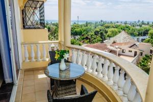 Un balcón con una mesa con un jarrón. en Ikhaya serviced Apartments With Sea View, Nyali, en Mombasa