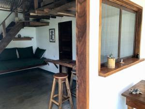 um quarto com um sofá verde e um banco em TwoTen° Surf Home em Popoyo