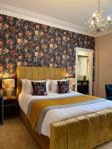 a bedroom with a large bed with a floral wallpaper at Rose Villa in Oban