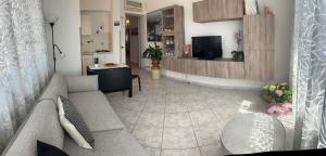 Una sala de estar con un sofá y un televisor. en Casa Vacanze vista mare a Castellabate, en Castellabate