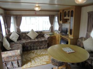 a living room with a couch and a table at 5 Berth on Coral Beach (Granada) in Ingoldmells