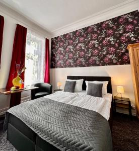 a bedroom with a large bed and a red wall at Hotel Nord in Hamburg