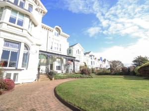 a large white house with a brick driveway at Ismay Billiard Room Apartment - Titanic Interest in Crosby