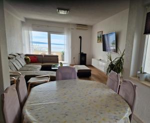 uma sala de estar com uma mesa e cadeiras e um sofá em Beautiful place near the sea em Podstrana