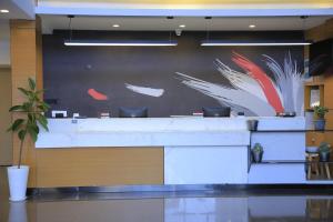 a lobby with a wall with a painting of birds at IVY Hotel Addis Ababa Airport branch in Addis Ababa