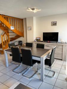 a dining room with a table and chairs and a television at Appartement centre ville Luz Saint Sauveur T4 pour 10 personnes in Luz-Saint-Sauveur