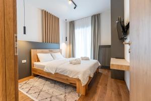 a bedroom with a bed with white sheets at Aparthotel RAJSKA in Jahorina