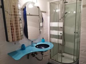 y baño con lavabo azul y ducha. en Amplio apartamento 1 dormitorio - Playa Paraiso, en Playa Paraiso