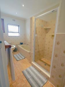 a bathroom with a shower and a tub at Tyger Classique Self-Catering Cape Town, Tyger Valley in Bellville