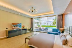 une chambre d'hôtel avec un lit, un canapé et une télévision dans l'établissement Deluxe Beach Villas by Danatrip, à Đà Nẵng 55 autres photos