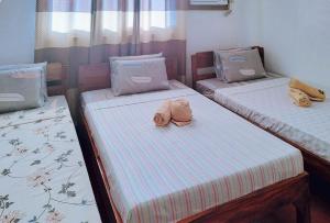 um quarto com três camas com bichos de peluche em RedDoorz @ Reana Seaside Pensione House Guindulman em Guindulman