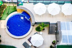 uma vista sobre uma piscina com guarda-sóis e cadeiras em Hotel Golden Park Recife Boa Viagem em Recife
