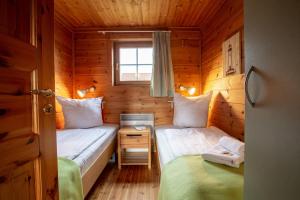 a small room with two beds in a wooden cabin at Typ D "Gorch Fock" -Schärenhaus- in Pelzerhaken