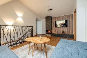 a living room with a table and a couch at Aparthotel RAJSKA in Jahorina