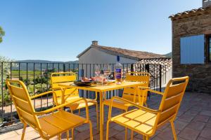 une table et des chaises jaunes sur une terrasse dans l'établissement Domaine deï Luppi - Mas Provençal et Cabanon - Golfe de Saint-Tropez - piscine privée, au Plan-de-la-Tour