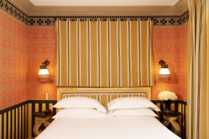 a bedroom with a bed and a striped wall at Hôtel Bourg Tibourg - Paris Marais in Paris