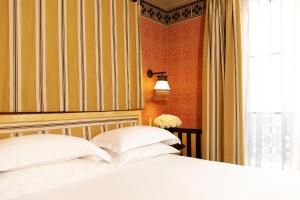 a bedroom with a bed with white pillows and a window at Hôtel Bourg Tibourg - Paris Marais in Paris +54 photos