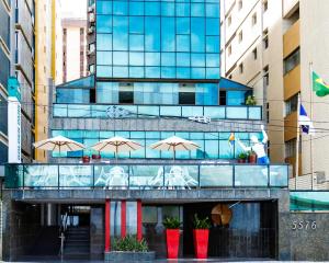 um edifício com guarda-chuvas à frente em Hotel Golden Park Recife Boa Viagem em Recife