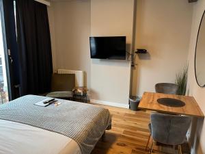 a hotel room with a bed and a table and a tv at Good night Leuven -Self check-in in Leuven