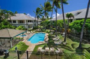a resort with a swimming pool and palm trees at Regency at Poipu Kai 323 in Koloa