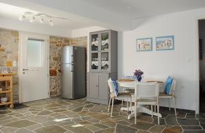 a kitchen with a refrigerator and a table and chairs at Sunrise View Lefkes in Lefkes