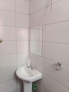 a white bathroom with a sink and a mirror at Greenvale's 2 Bedroom in Eldoret