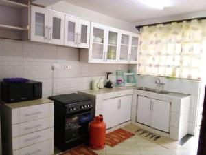 a kitchen with white cabinets and a red fire hydrant at Greenvale's 2 Bedroom in Eldoret