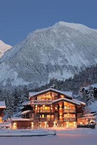 un grande edificio con una montagna sullo sfondo di Chalet Le Moulin, Courchevel Le Praz, 6 chambres, Ski in, Ski out a Courchevel