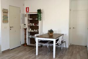 una sala da pranzo con tavolo e sedie bianche di CHALET CON PISCINA PRIVADA a Torrevieja