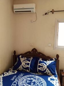 - une chambre avec un lit et un climatiseur mural dans l'établissement Résidence La ROSÉE, à Yaoundé