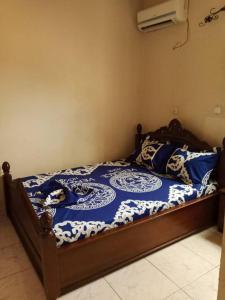 a bedroom with a bed with a blue and white comforter at Résidence La ROSÉE in Yaoundé