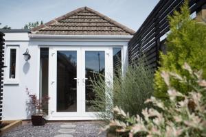a white door on a white house at Cwtch, cozy studio, private, separate entrance. in Cardiff