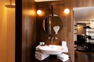 uma casa de banho com lavatório, espelho e toalhas em Hôtel Bourg Tibourg em Paris