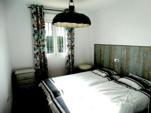 阿爾凱德薩的住宿－Casa Alcaidesa，一间卧室设有一张大床和一个窗户。