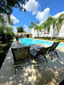- deux chaises assises à côté de la piscine dans l'établissement Preciosa Casa Ideal Familias en Privada - Pool, à Playa del Carmen