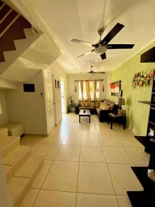 - un salon avec un ventilateur de plafond et un canapé dans l'établissement Preciosa Casa Ideal Familias en Privada - Pool, à Playa del Carmen