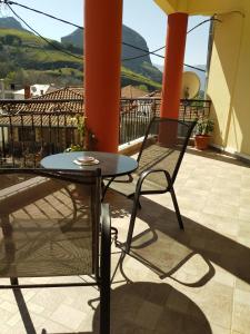 una mesa y una silla en un balcón con vistas en Guesthouse Lithos, en Kalambaka